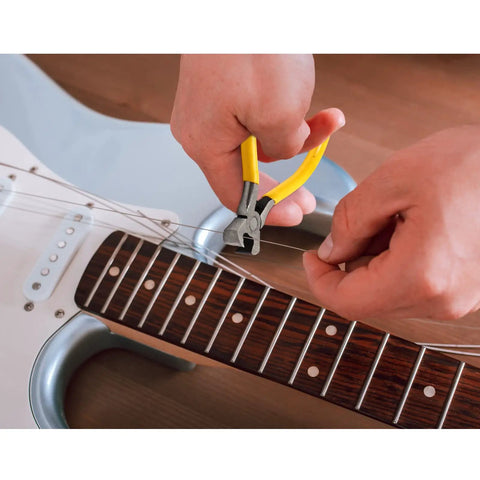 Using pliers from All In One Guitar Repair Kit With Neck Rest Cradle And Pro Grade Gig Ready Work Mat For Studio And Shop to cut strings