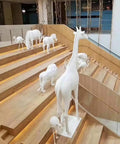 White animal statues on wooden staircase in modern atrium