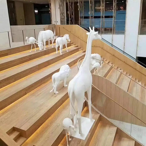 White animal statues on wooden staircase in modern atrium
