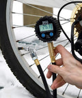 JACO ElitePro digital tire pressure gauge with hose attached to bicycle tire valve, close-up view.