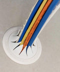 Front view of a white Speedy’Z 2-inch cable pass port with multiple colored cables inserted, mounted on a smooth gray surface.