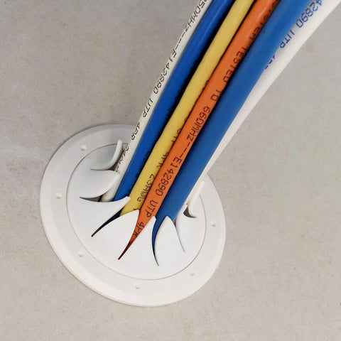Front view of a white Speedy’Z 2-inch cable pass port with multiple colored cables inserted, mounted on a smooth gray surface.