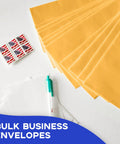 Open End Manila Envelopes 7.5 By 10.5 Inches Yellow 100 Pack With Peel And Seal Closure, stamps and a pen on a desk