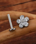 Top Shelf 16G Flower Cartilage Piercing Jewelry In ASTM F136 Titanium Hypoallergenic Flat Back Studs, silver flower stud earring on a wooden surface.