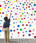 Child reaching up to 264 Piece Polka Dot Wall Decals Set Colorful Vinyl Circle Dots for Walls Perfect for Kids Bedrooms Nurseries Playrooms and Classrooms 7 Sizes 12 Bright Colors Easy Peel And Stick Stickers on wall