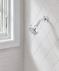 Ignite Chrome Five Function Shower Head With 2.5 GPM High Pressure Spray installed in bathroom with white tile wall.