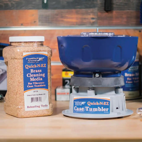 Quick N EZ Vibratory Case Tumbler with clear viewing lid and brass cleaning media jar on a wooden table