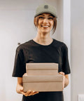 Person wearing lightweight low profile trucker hat for men apricot washed cotton dad cap with adjustable strap, smiling indoors.