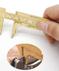 Close-up of Brass Pocket Vernier Caliper Ruler, Handy Sliding Gauge, Mini Vernier Caliper With Dual MM and Inch Scales in use.