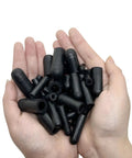 Hand holding assorted rubber vacuum cap kit for automotive hoses and vacuum lines includes caps ranging three sixteenths to three eighths inch