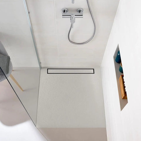 Overhead view of 24 Inch Matte Black Linear Shower Drain With Hair Catcher And Leveling Feet Rectangle Tile Insert Cover Reversible 2 In 1 Drain 304 Stainless Steel Bathroom Floor Drain Heavy Duty No Nonsense Rust Proof Easy Install set in a modern bathroom floor.
