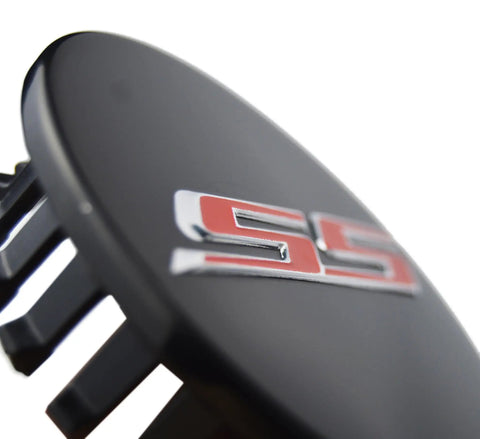 Fresh Set Of Four 68 Millimeter Stainless Steel Wheel Center Caps Featuring Raised Double Slash SS Badges For Chevy Camaro Rim Covers close-up showing stainless steel emblem.