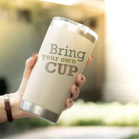 Person holding a 20 oz tumbler with 'Bring your own CUP' text outdoors, suitable for Elastic Sublimation Tumbler Holder Ring Bands usage.