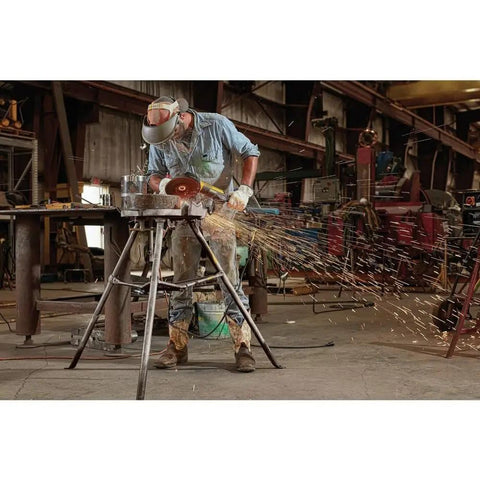 Worker using RAT Tail 7 Inch Angle Grinder with 13 Amp Brushless Motor, sparks flying on heavy-duty jobsite.