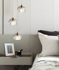 Modern Raindrop Pendant Lights Set Of 3, brass round hanging lamps with clear crystal prisms in a cozy bedroom setting.