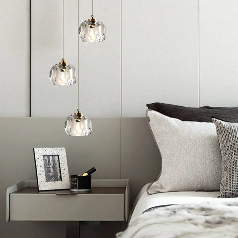 Modern Raindrop Pendant Lights Set Of 3, brass round hanging lamps with clear crystal prisms in a cozy bedroom setting.