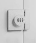 Solid Keyless Cabinet Lock With Three Digit Combo For Sliding Doors And Drawers Featuring Anti Pry Bar And No Sweat Install White Finish mounted on a white cabinet.