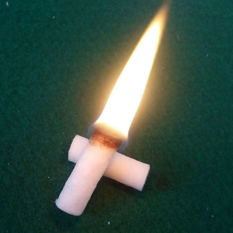Easy Light Tinder for Camping and Survival with flame, natural wood fiber lit on green surface