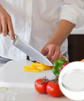 Heavy Duty Adhesive Non Slip Bumper Dots For Glass Tables And Cabinets Provide Dang Good Grip While Keeping Furniture Straight Up Safe From Daily Scratches And Slipping Hazards. A close-up of a chef slicing yellow bell peppers on a cutting board with fresh vegetables visible.