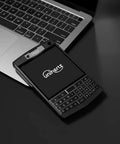 Tough As Nails Rugged QWERTY Smartphone Powered By Rock Solid Android 10 Platform beside a laptop on a black surface.