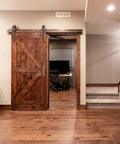 Home office with a wooden barn door featuring vintage solid brass pulls in antique copper finish for rustic charm and functionality.