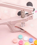 Close-up of a pink Snap Pliers Set For T3 T5 T8 KAM Snaps Handheld Button Fastener Press Attacher installing snaps on fabric.