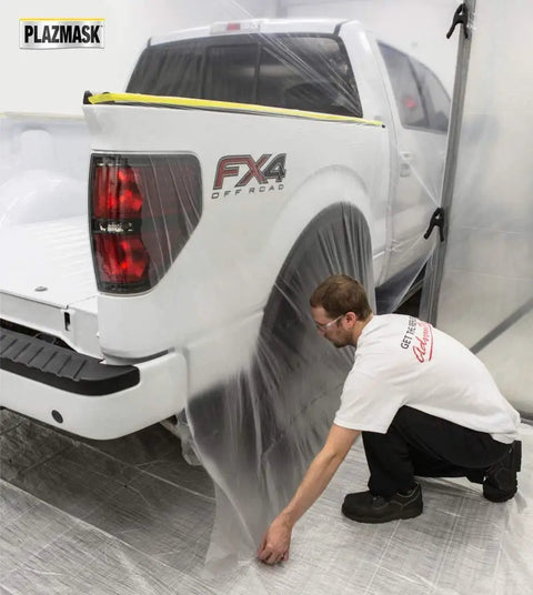 Man applying Pre-Taped Masking Film With Built-In Three Quarters Inch Tape, 0.5 Mil Thick Protective Film, on a truck for automotive painting.