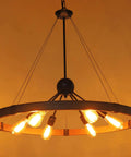 31.5 Inch Farmhouse Chandelier With Rustic Wagon Wheel Silhouette in Vintage Rust and Black Finish, illuminated view