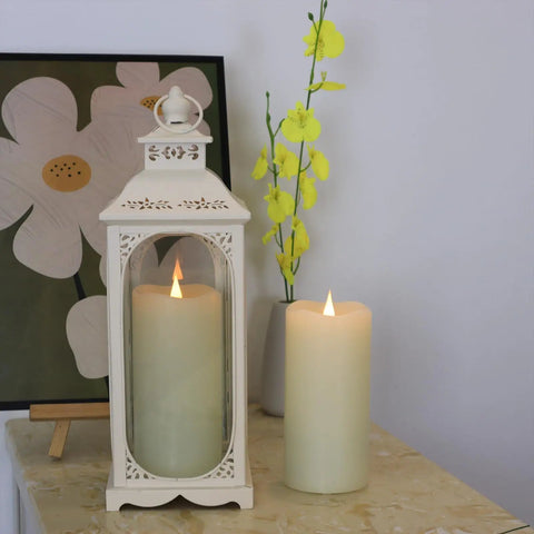 Ivory flameless LED candle with 3D moving wick flicker next to decorative lantern on table, creating cozy ambience.