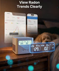 Smart WiFi Radon Detector For Home With Instant App Alerts And Continuous Daily Trend Tracking To Keep Indoor Air Crisp And Your Place Hella Safe All Year Long displaying radon levels and trends on a bedside table.