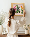 Woman hanging Wildflower Punch Needle Kit Two Pack For Beginners, Embroidery Set with frame and pre-printed fabric on wall