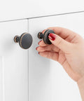 Top Shelf Round Oil Rubbed Bronze Cabinet Knobs 1 1/4 Inch Built Tough Rust Resistant Kitchen Hardware 30 Pack Including Mounting Screws For Quick DIY Refreshes And Smooth Everyday Grip being used on cabinet.