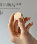 Hand holding Five Pack Solid Brass Cabinet Knobs Brushed Gold Handles For Dresser Kitchen Bedroom Bathroom modern hardware