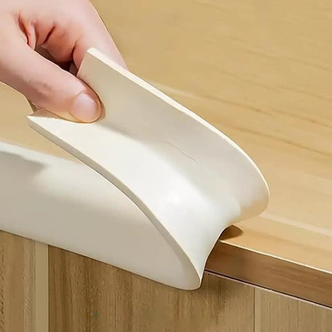 Soft Auto Adhesive Furniture Corner Protector For Edges Baby Proof Corner Guard being installed on a wooden table edge.
