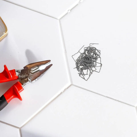 Get That Car Back Looking Fresh With Premium Steel Welding Staples For Bumper And Dashboard Repair Effortlessly Fix Dents Using These 0.8mm Plastic Welding Wire Essentials Today. Close-up of red-handled pliers with steel welding staples on a tiled surface.