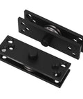 Front view of black concealed door hinge plates with roller pivots; two-piece metal hinge set with multiple screw holes