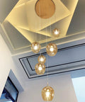 Dimmable Glass Globe Pendant Light Fixture With Champagne Finish, modern LED lamp with adjustable cords hanging in room