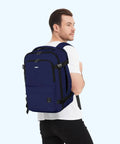 Man wearing Go To Underseat Personal Item Travel Backpack With 10 Pockets And 180 Degree Opening 15.6 Inch Laptop Carry On Bag in navy blue.