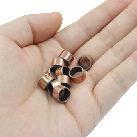 Hand holding 10 Piece Oilless Sleeve Bearings Set With 8mm Bore 10mm OD And 6mm Length Wrapped Bushings Bronze Sintered Coated
