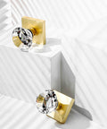 Two crystal glass dummy door knobs with satin brass finish, showing non-turning diamond square crystal design on white display
