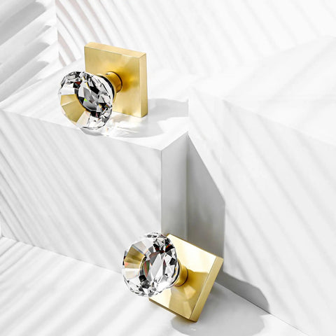 Two crystal glass dummy door knobs with satin brass finish, showing non-turning diamond square crystal design on white display