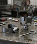 Heavy Duty Three Piece Drain Auger Set Featuring Tough As Nails Steel Cutter Heads For Knocking Out Grease And Hair Clogs In 4 Through 8 Inch Pipes Making Your Plumbing Run Sweet on a workbench.