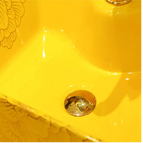 Close-up of the gold bathroom ceramic vessel sink bowl, highlighting the polished drain in a vibrant yellow sink.