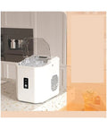 Portable Ice Maker Cranking Out Twenty Six Pounds Daily Produces Nine Bullet Cubes In Six Flat Minutes, white countertop model with ice.
