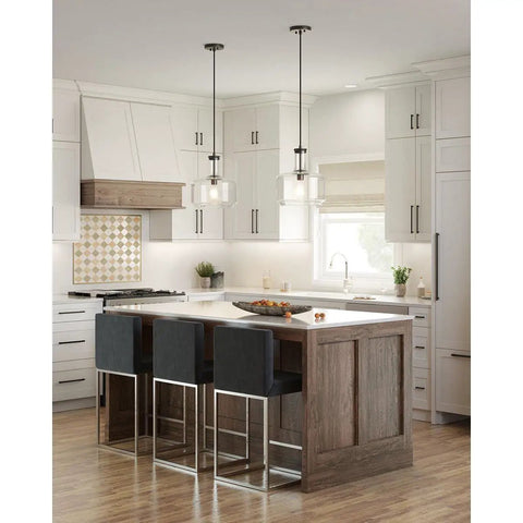 Latrobe Collection 1 Light Clear Glass Coastal Pendant Light In Matte Black above kitchen island with bar stools.