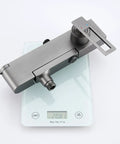 Wall Mounted Exposed Shower System with Tub Spout 90° Rotating Gun Gray faucet on a digital scale showing 20.81 kg.