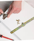 Close-up of QUMIIRITY adjustable angle furniture hinge with rainbow-finish mounting bar, gear wheel, and screws