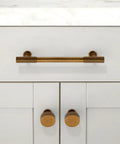 Slick Antique Brass Cabinet Knobs Two Pack Single Hole Round Drawer Pulls For Kitchen Cupboards And Dressers mounted on cabinet doors.