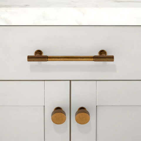 Five Pack Antique Brass Cabinet Knobs and Round Single Hole Pulls on white kitchen drawer for hardware upgrade