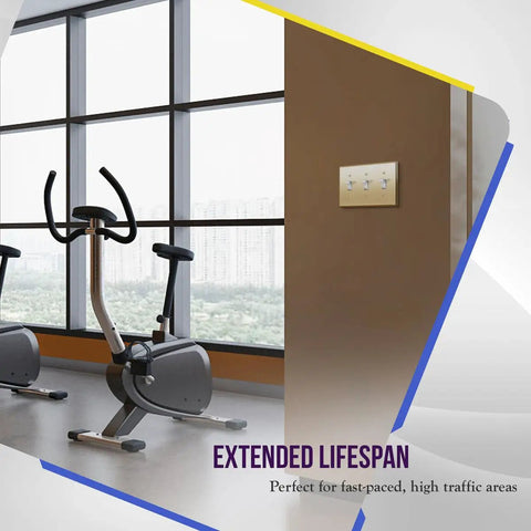 Gym with Toggle Light Switch Wall Plate, Metal 3-Gang 4.50 x 6.38 Inches, Brass Gold Finish, on brown wall next to exercise bikes.